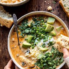 two bowls of soup with bread and avocado garnished with cilantro