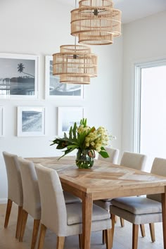 a dining room table with chairs and a chandelier hanging from it's ceiling