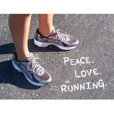 a woman's feet standing in front of a sign that says peace, love, running