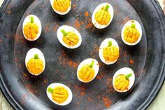 deviled eggs are arranged on a black plate