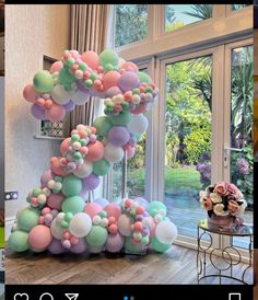 the balloon arch is decorated with pastel colors