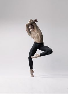 a shirtless man is doing a split in the air