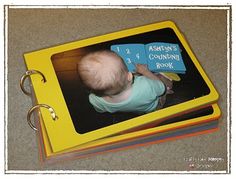 a baby is sitting on top of a yellow book with an arrow's counting book attached to it