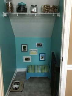 a room with blue walls and pictures on the wall, including a dog bed in the corner