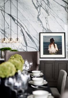 a dining room table with plates and silverware in front of a framed photo on the wall