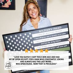 a woman holding up a large framed american flag with the words soldier's creed written on it