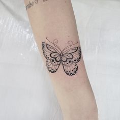 a small butterfly tattoo on the arm