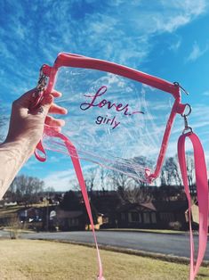 a person holding up a clear sign with the word love girl written on it in front of a blue sky