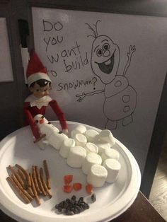 an elf making marshmallows on a plate with the words do you want to build snowmen?