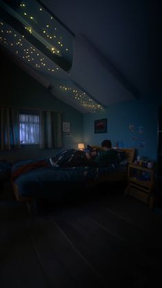 two people laying on a bed in a dark room