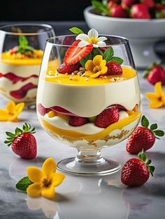 two dessert dishes with strawberries and flowers on the table