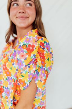 Unleash your dreamy side with our Dream Floral Top! Featuring a bright, multicolor floral print on a crisp white base, this top will add a pop of color to any outfit. The ruffle neck and ruched shoulder add a touch of charm to this playful piece. (It's perfect for a fun and flirty look!) Model is wearing a small and is 5'3" Plus model is wearing a 1X and is 5'8". Size Chart Length Bust S 24" 41" M 25" 43" L 25" 45" 1x 27" 50" 2x 28" 52" 3x 28" 54" *All measurements are approximate and done while Spring Ruffle Sleeve Tops For Garden Party, Ruffle Sleeve Tops For Spring Garden Party, Garden Party Tops With Flutter Sleeves And Floral Print, Spring Multicolor Tops With Ruffle Sleeves, Multicolor Floral Print Top For Brunch, Feminine Multicolor Tops With Ditsy Floral Print, Feminine Multicolor Top For Garden Party, Floral Print Multicolor Top For Brunch, Feminine Multicolor Ditsy Floral Print Tops