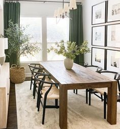 a dining room table with chairs and pictures on the wall