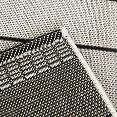 black and white woven material with small dots on it's edges, close up