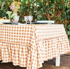 the table is set with two glasses and plates on it, ready to be served