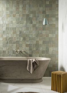 a bath tub sitting next to a wooden stool