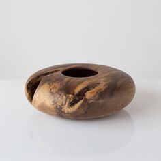 a wooden vase sitting on top of a white table