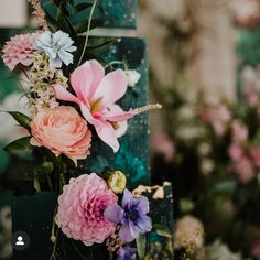 pink and blue flowers are on top of a green box