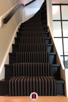 the stairs are lined with black and white carpet