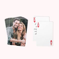 two playing cards, one with a couple's photo and the other with hearts on them