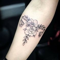 a black and white flower tattoo on the right arm, with leaves around it's edges