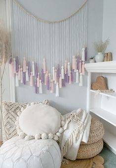 a white couch sitting next to a shelf filled with pillows