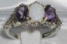 "A stunning made to order 18K White Gold ornate Trilogy Ring handset with a natural Australian Opal and two vibrant dark natural Amethysts The centre opal measures 8 x 6mm (0.32\" x 0.24\") and the two 7 x 5mm (0.28\" x 0.20\") vibrant natural Amethysts The gemstones are natural, earth-mined and ethically sourced and weigh: Opal 0.75ct Amethyst 1.5ct All of our jewellery is fully tested and hallmarked by the London, Birmingham or Dublin Assay Office, giving you the assurance of a high quality pi Trilogy Ring, Carved Ring, Precious Opal, Australian Opal, Natural Opal, Anniversary Ring, Amethyst Ring, Pink Tourmaline, Victorian Fashion