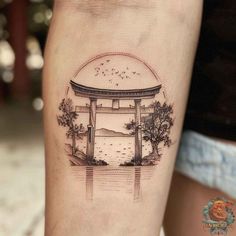 a woman's leg with a tattoo on it that has an image of a japanese gate