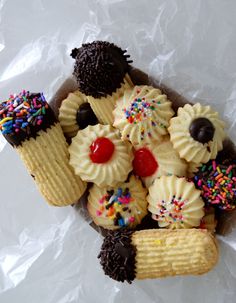 cupcakes with sprinkles and chocolate on top in a paper wrapper