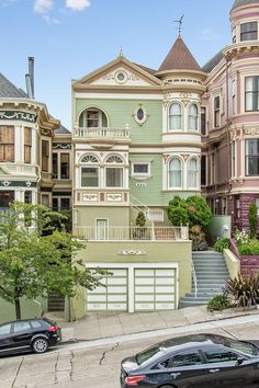 a row of houses with cars parked on the street