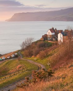 a house sitting on top of a hill next to the ocean