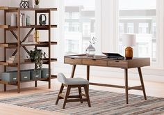 a room with a desk, chair and bookcases in it on the floor