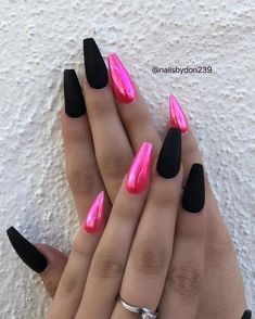 two hands with black and pink nail polish on them