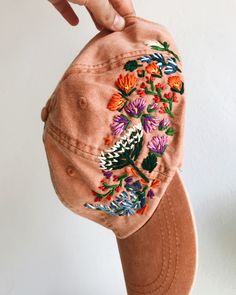 a woman's hat with embroidered flowers on the front, and an instagramr below