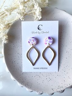 Pink and purple polymer clay earrings. Made using a lightweight polymer clay material. All products are individually handmade and therefore, there may be slight differences in colours, shapes and textures.  All earring posts and backs are made using gold plated stainless steel. This makes all earrings suitable to wear for even the most sensitive ears.. How to care for your earrings: ♡ Store your earrings in a clean, dry place and avoid exposure to perfume, lotions etc. ♡ Remove your earrings before any contact with water (swimming, showering) ♡ Remove makeup or dirt with  a slightly damp soft cloth or makeup wipe Thank you for visiting my store and supporting small businesses 🌸 Purple Dangle Polymer Clay Jewelry, Handmade Purple Polymer Clay Earrings, Purple Polymer Clay Drop Earrings, Elegant Purple Polymer Clay Earrings, Purple Polymer Clay, Clay Material, Makeup Wipes, Earrings Clay, Earring Posts