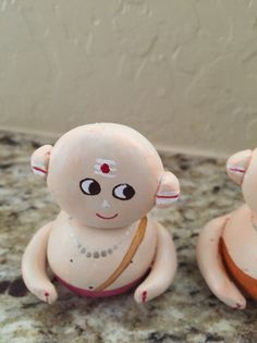 two small figurines sitting on top of a counter