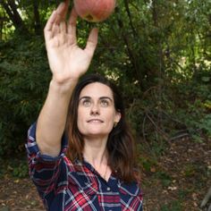 a woman holding an apple up in the air