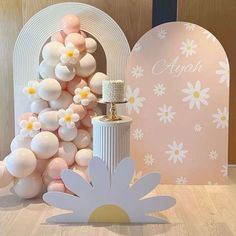 a table topped with balloons and a vase filled with flowers