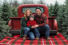 a man and woman sitting in front of a red truck with christmas trees