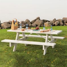 a picnic table with food on it in the grass