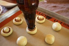 an image of doughnuts being made on a baking sheet with a bottle in the background