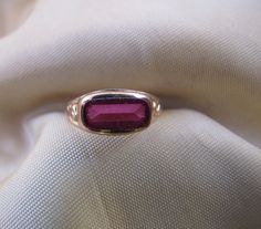 The color of this synthetic Spinel is a deep rose-pink, and the setting is delicate, with a small, subtle decoration on the sides of the shank. Synthetic Spinels were used frequently in Victorian and Edwardian jewelry. 10k gold. Size 5. Classic Pink Rings With Bezel Setting, Classic Pink Bezel Set Ring, Classic Pink Ruby Ring For Formal Occasions, Classic Pink Gold Rings For Formal Occasions, Formal Pink Solitaire Ring, Formal Pink Ruby Ring, Pink Hallmarked Victorian Ruby Ring, Victorian Pink Hallmarked Ruby Ring, Pink Victorian Hallmarked Ruby Ring