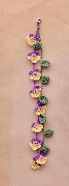 crocheted flowers and leaves are attached to a string