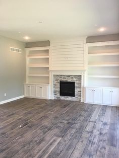 empty living room with fireplace and built - in bookcases