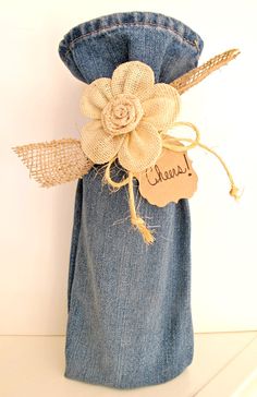 a denim bag with a flower on it and a name tag attached to the side