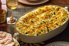 a casserole dish with cheese and spinach in it on a wooden table