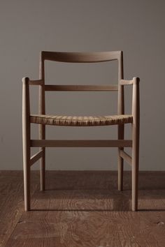 a wooden chair sitting on top of a hard wood floor next to a white wall