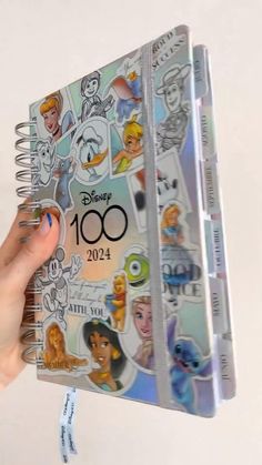 someone is holding up a disney book with stickers on it