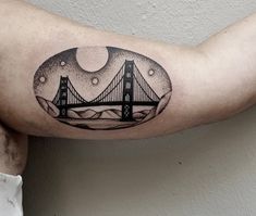 a man's arm with a black and white drawing of the golden gate bridge