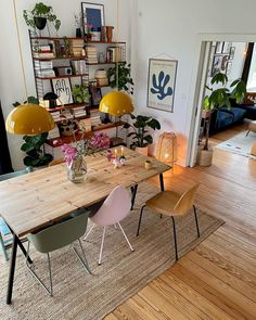 a dining room table with two chairs and a vase filled with flowers on top of it